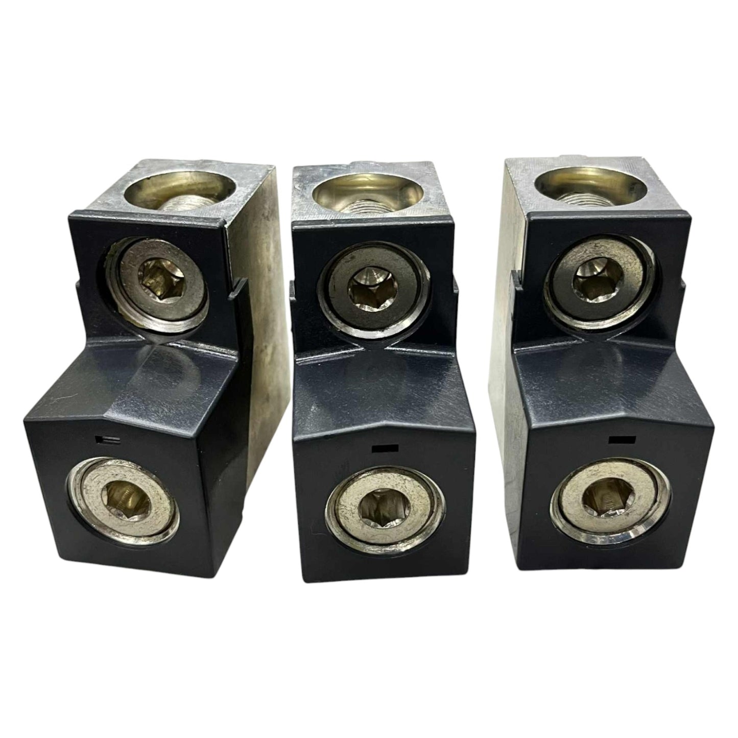 Three black metal blocks with brass-colored circular components on a white background