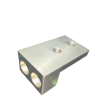 Metallic block with three circular holes on a white background