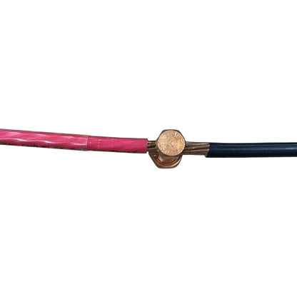 Close-up of a cable with pink insulation and brass connector on a white background