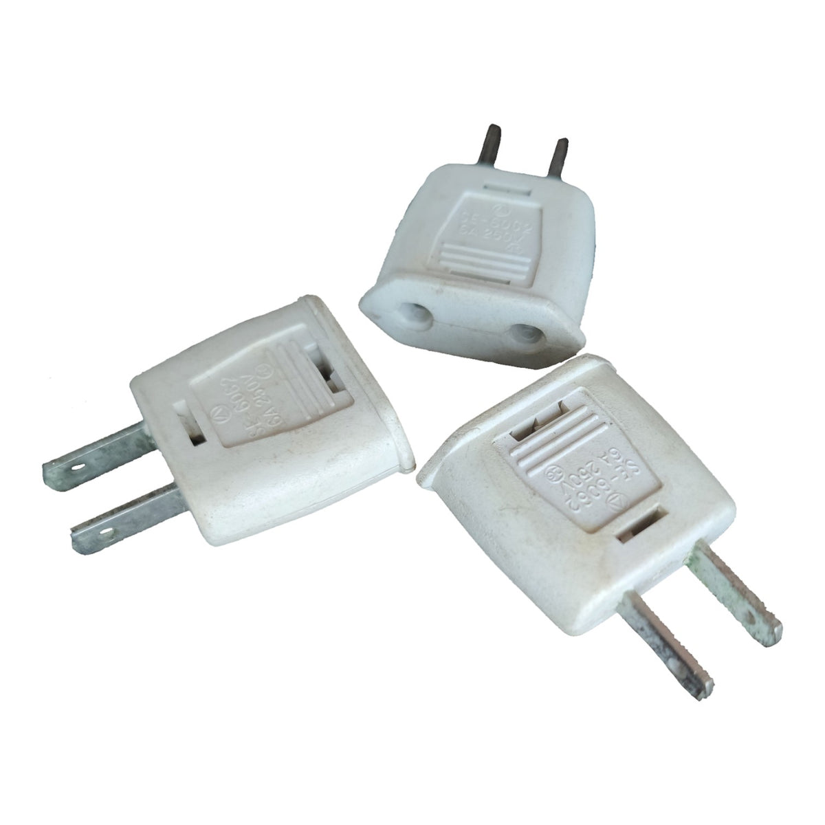 Three white plastic US to European plug adapters with two metal pins, shown on a plain white background.