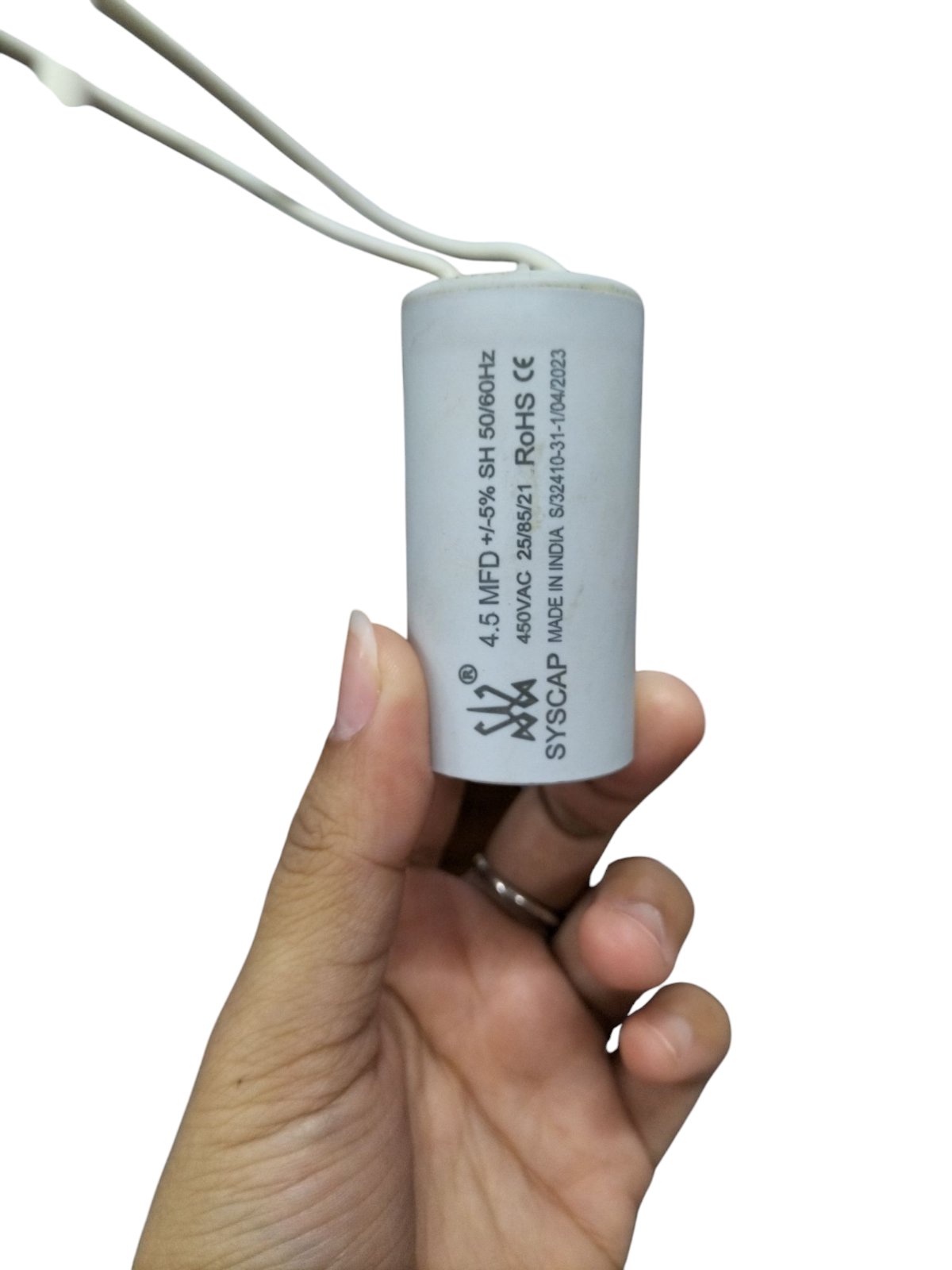 Syscap 450vac Motor Running Capacitor held in hand, used for improving motor efficiency