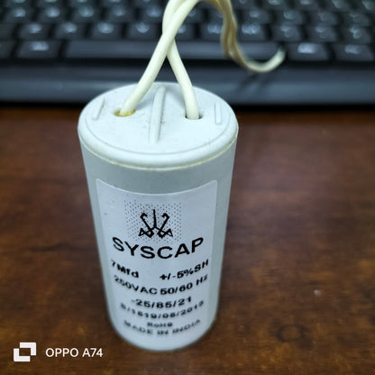 Syscap 7 Microfarad AC Motor Capacitor with white casing and wires for electrical circuits