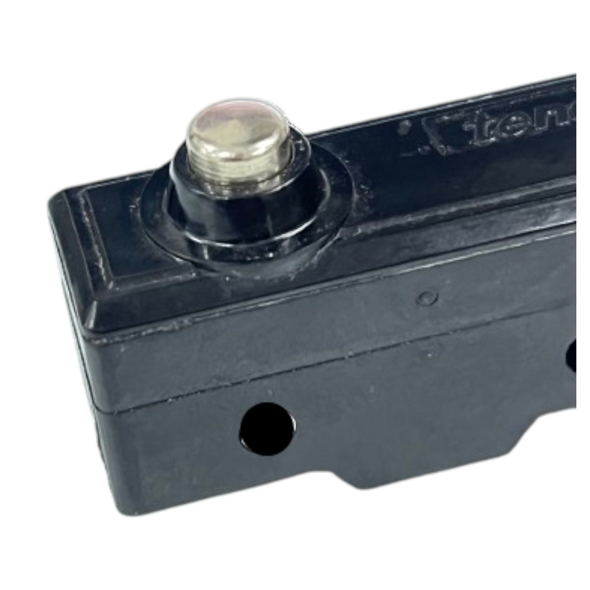 A close-up of a black plastic component with a circular transparent cap or lens on top, photographed against a plain white background.