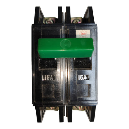A 15A double-pole electrical circuit breaker with a prominent green handle on a black plastic housing, shown against a plain white background.