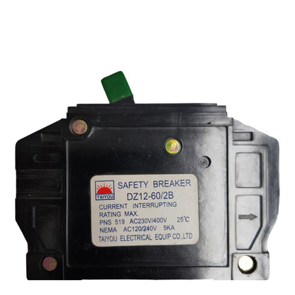 A black industrial safety breaker with a white label and a small green tab, photographed on a plain white background.