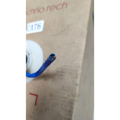 A close-up of a blue multi-core cable showing its inner multi-colored wire strands, positioned in front of a brown cardboard box with 'chino tech' printed on it.