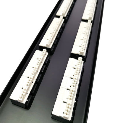 A close-up of a black cable management tray or channel with multiple white plastic connector blocks arranged in two rows, photographed on a white background.