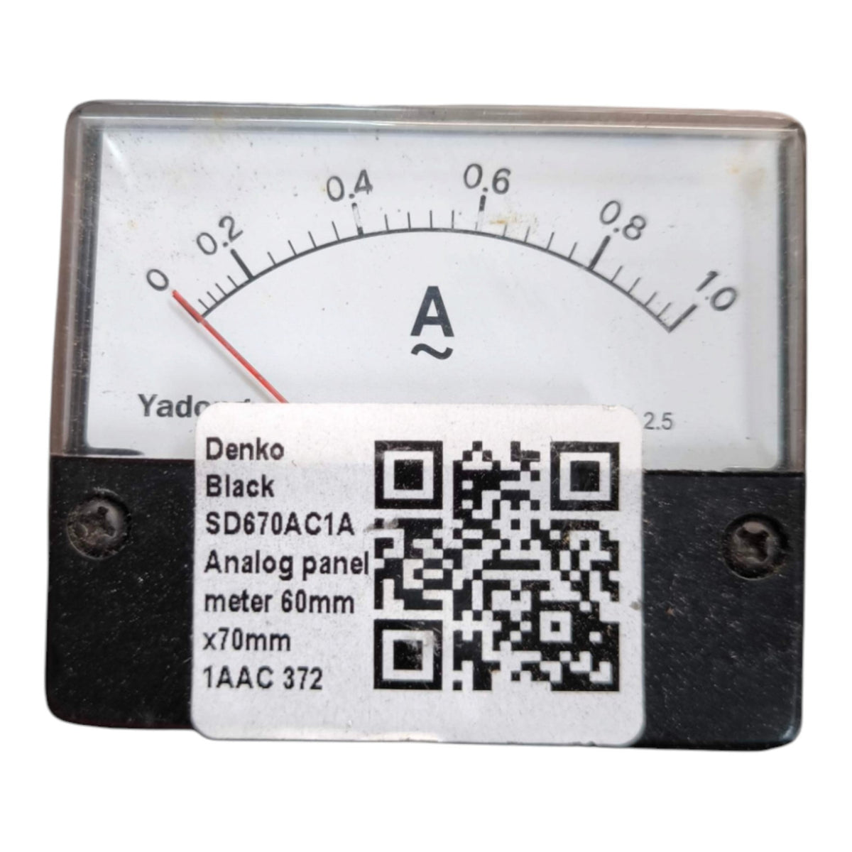 A rectangular black analog ammeter panel with a white dial and red needle, shown against a plain white background. A white sticker label is placed over the lower center, showing product details including the brand Denko and model SD670AC1A.