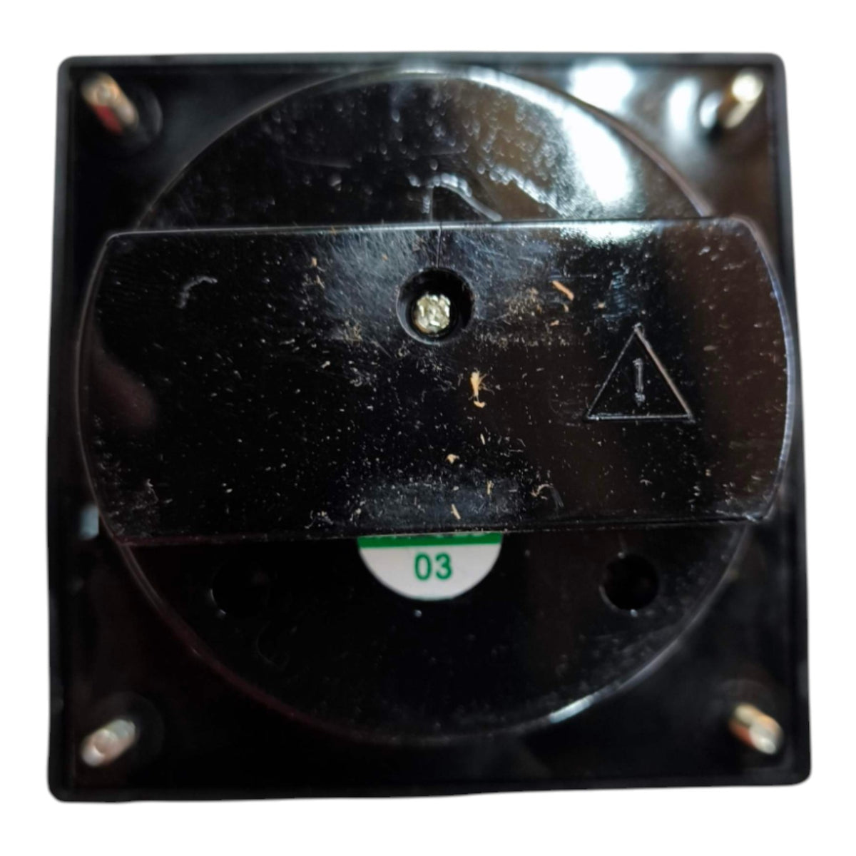 A close-up of a black electrical switch component with four mounting screws, a circular dial, and a small white label marked '03'.