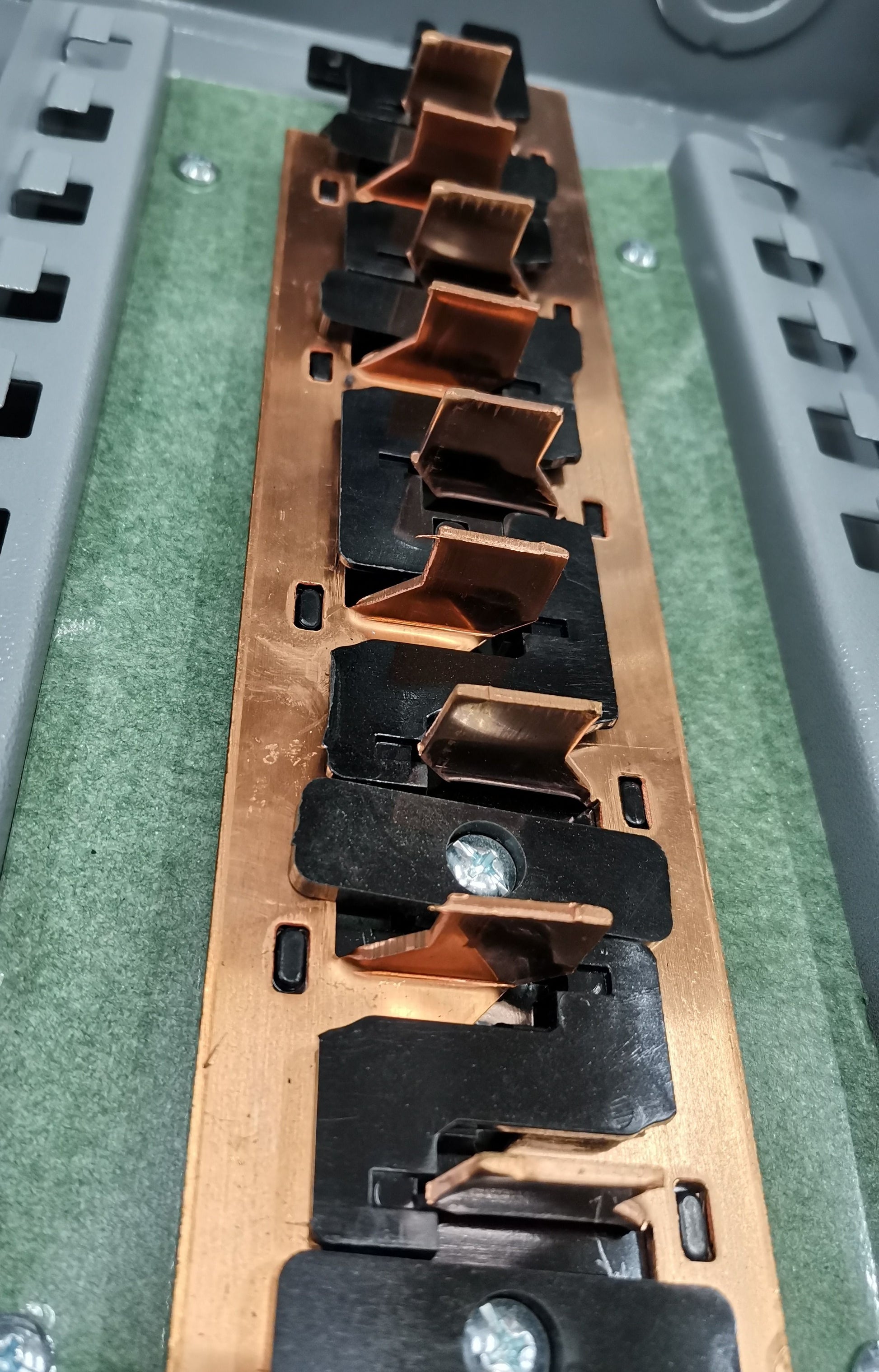 Panel board for 2 pole circuit breaker with copper connectors and mounting screws inside gray electrical box