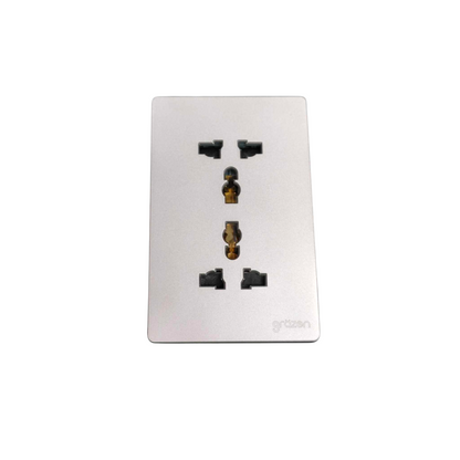 A rectangular silver metal wall outlet cover plate with four black socket outlets and a gold-toned center grounding pin, featuring the 'grattan' brand name in the bottom right corner, set against a plain white background.
