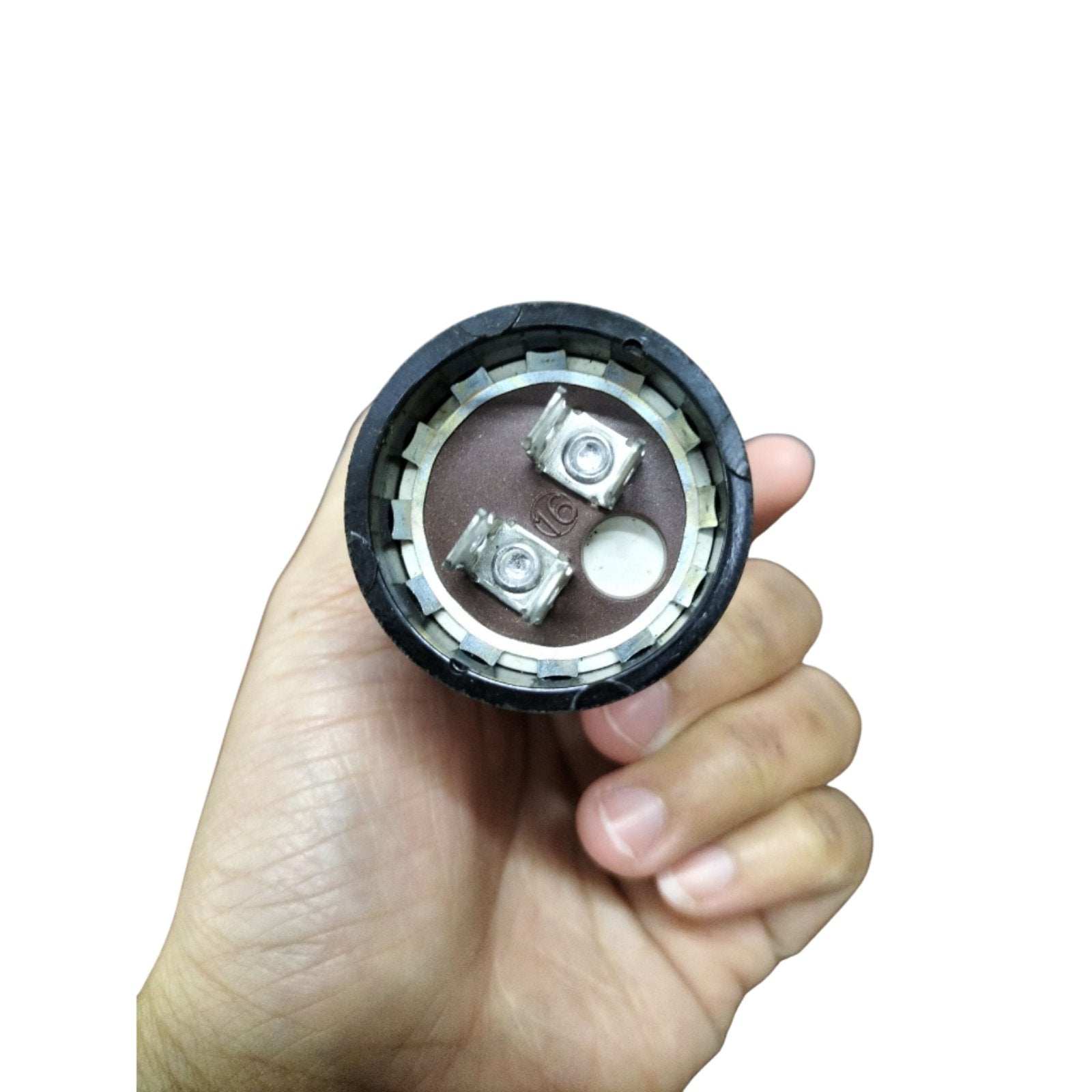 Motor start capacitor 30-36uf 330v held in hand, showcasing its compact design and terminal connections