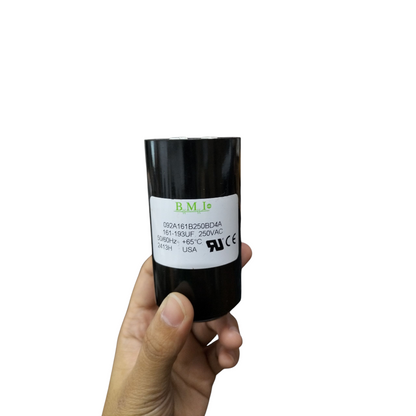 BMI starting capacitor 161-193UF 250V AC in a hand demonstrating size and design for electrical applications
