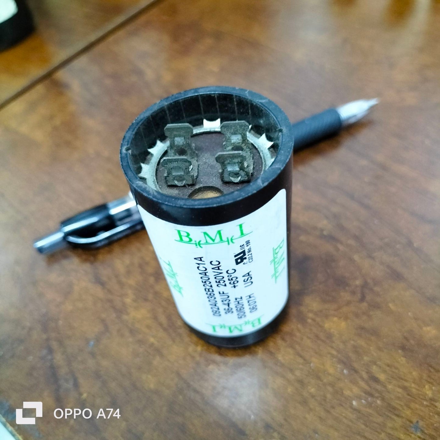 BMI Starting Capacitor 36-43 UF electrical part with black casing on wooden surface