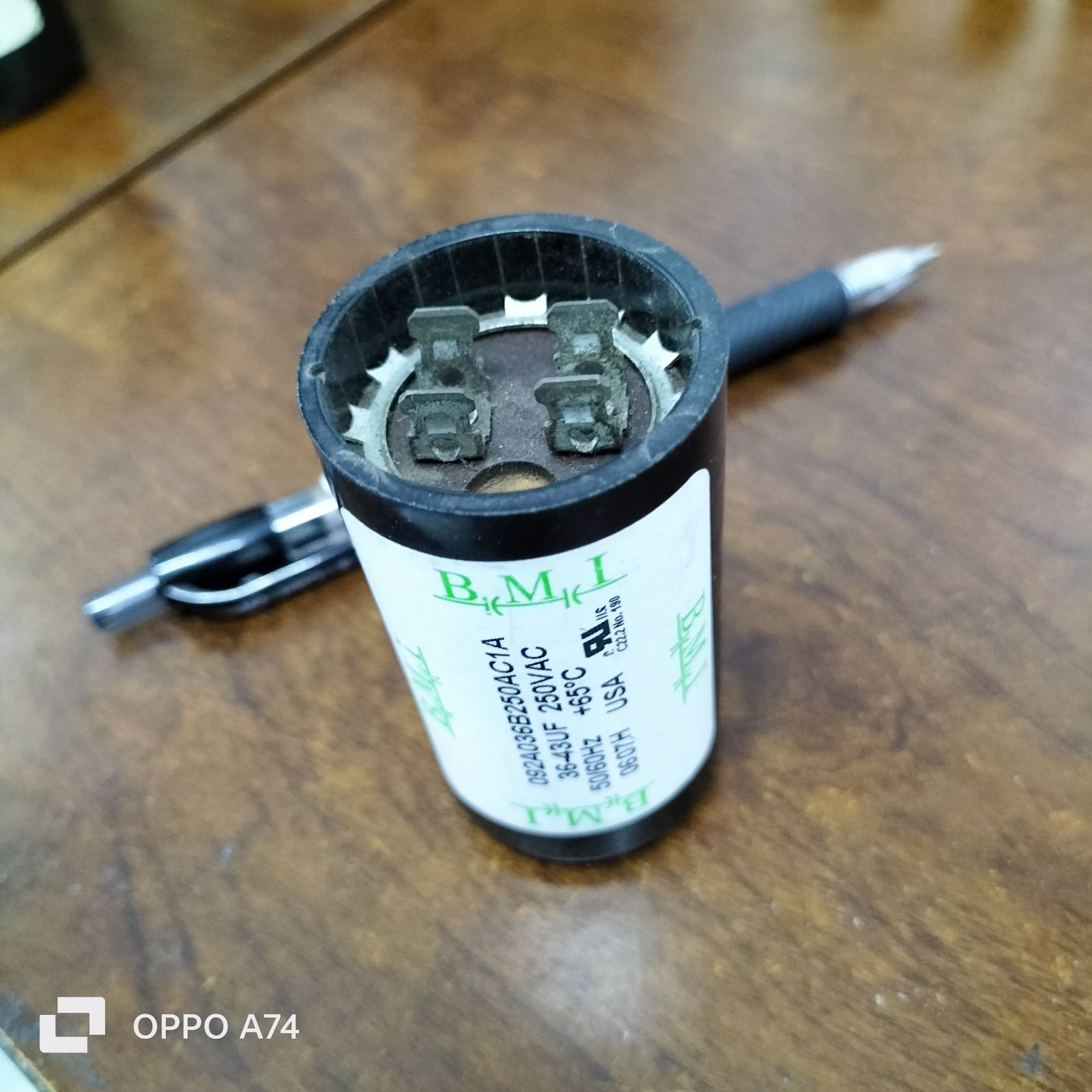 BMI Starting Capacitor 36-43 UF electrical part with black casing on wooden surface