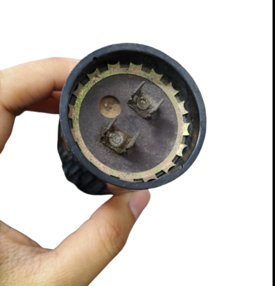 BMI Capacitor 324-388MFD 110-125V held in hand showcasing its electrical connections