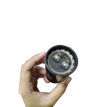 CDE 110-125V motor start capacitor held in hand showcasing its terminal connections