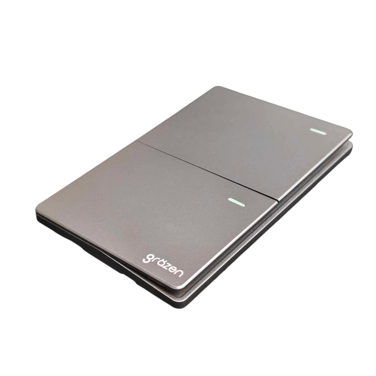 A closed metallic gray portable power bank by Grätzen, featuring a diagonal seam, two small green LED indicator lights, and the 'grätzen' brand logo printed in white near the bottom left corner, set against a plain white background.