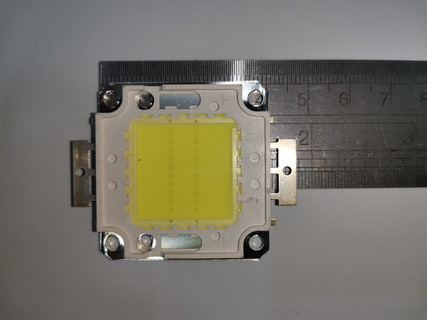 20w high power LED chip mounted on metal base with ruler for size measurement close up