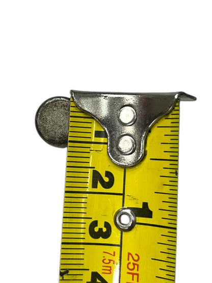 Close-up view of a metal clip on a yellow measuring tape for electrical circuitry parts