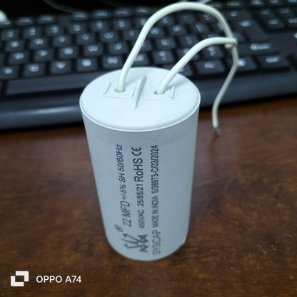 Syscap motor capacitor with white cylindrical body and attached wires