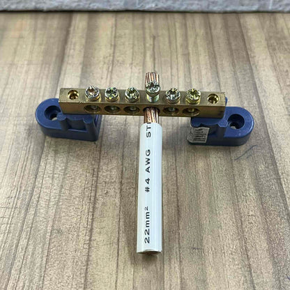Grippes Grounding Bus Bars 4 Holes with screws and attached copper wire on wooden surface