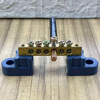 Grippes grounding bus bars 4 holes with mounted copper wire and blue mounting brackets on wooden surface