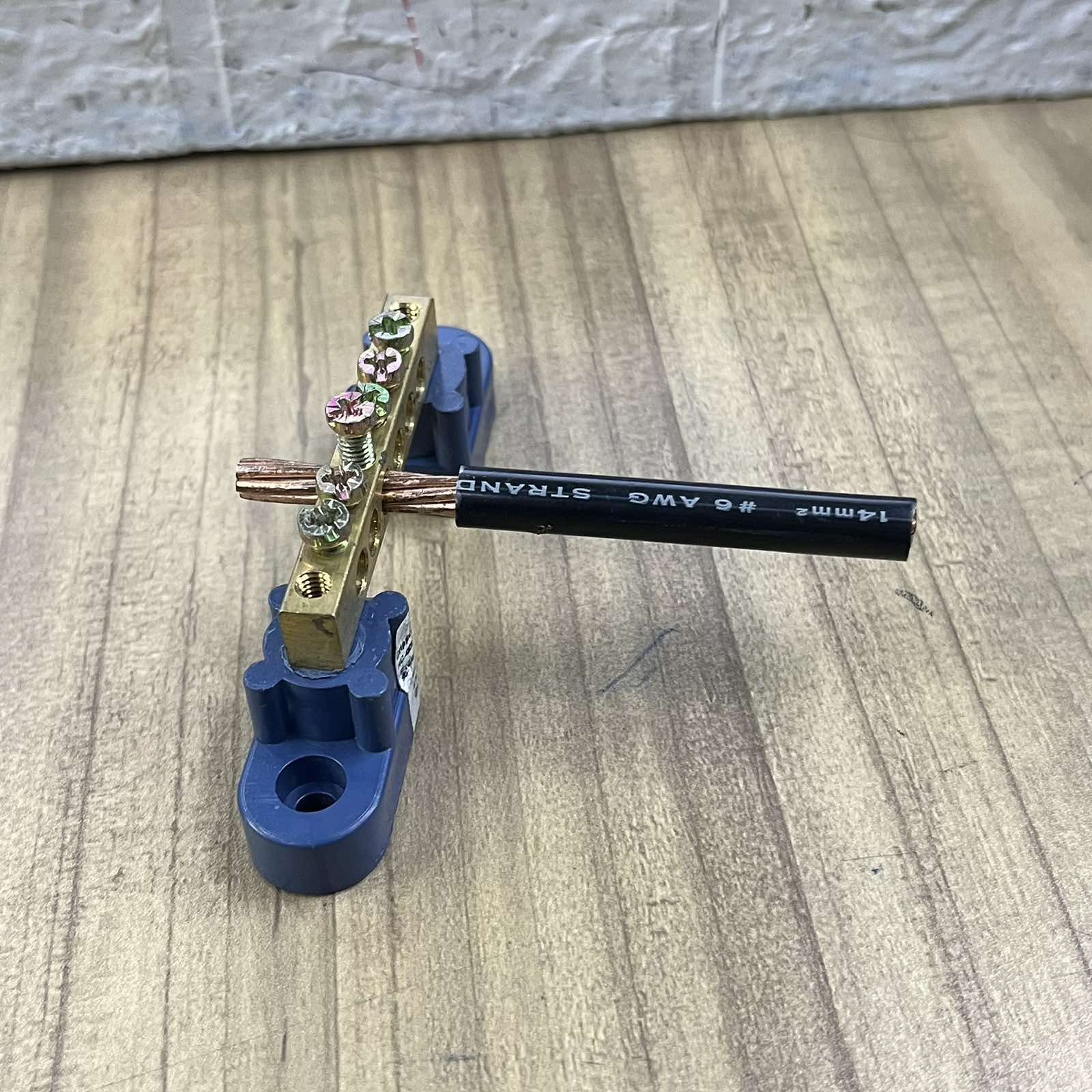 Grippes grounding bus bars 4 holes mounted with attached copper wire on wooden surface