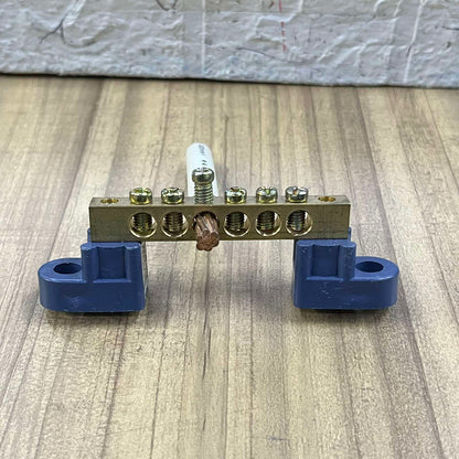 Grippes Grounding Bus Bars 4 Holes electrical part with brass bar and blue mounts on wooden surface
