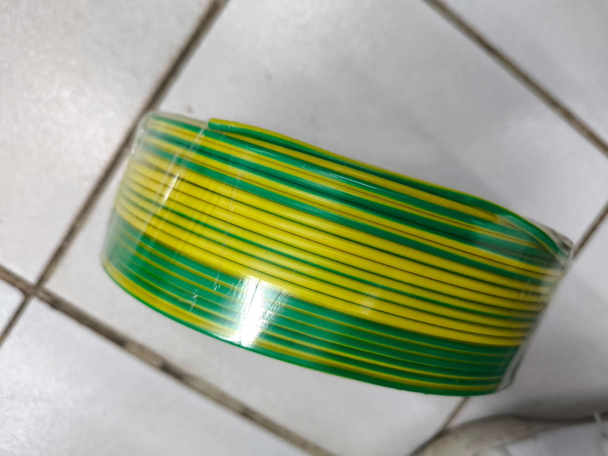Roll of green and yellow Grounding Cable 2.0mm AWG14 wires coiled on a tiled floor