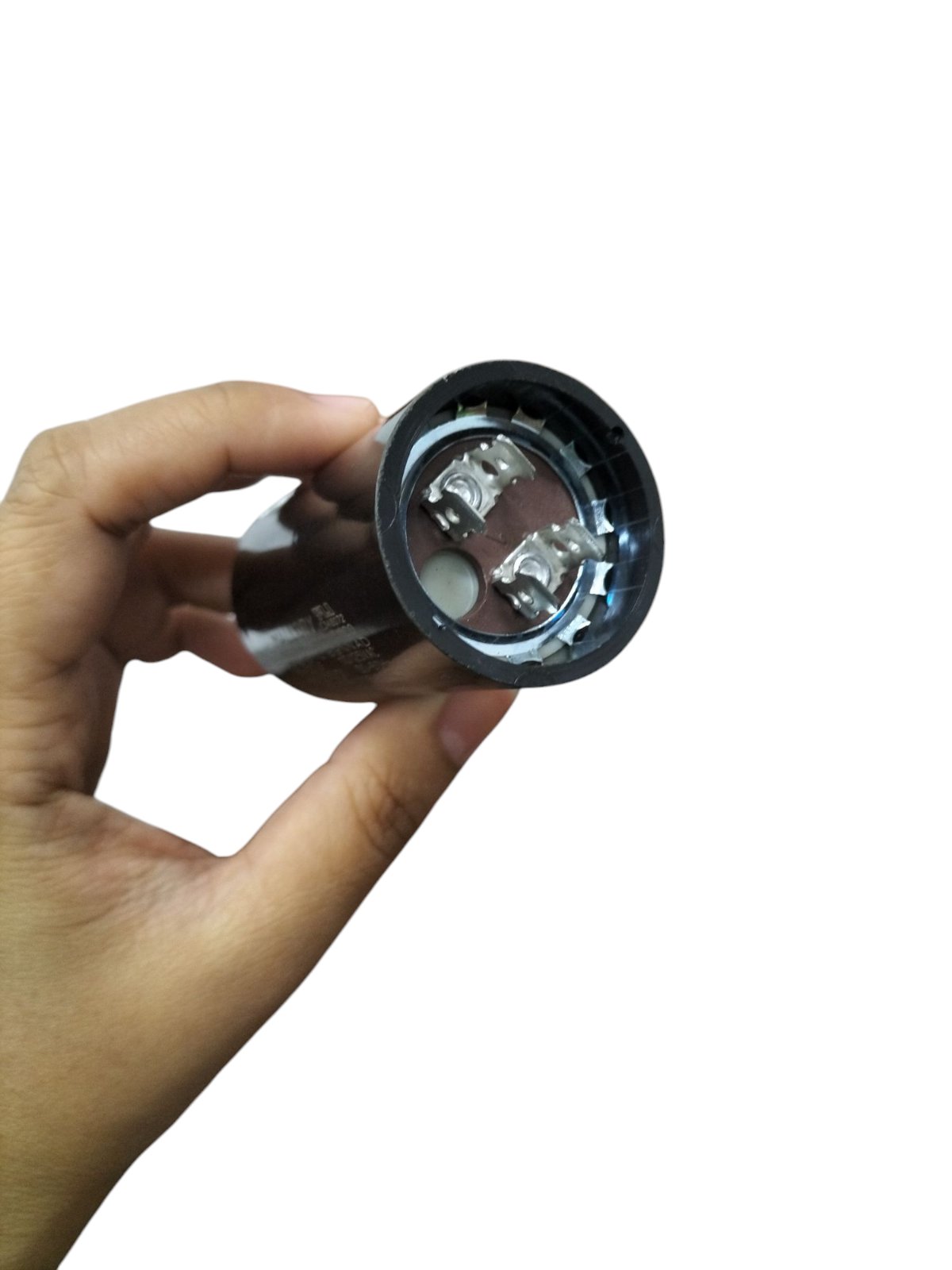 Mallory electric motor start capacitor held in hand showing electrical terminals for motor circuits