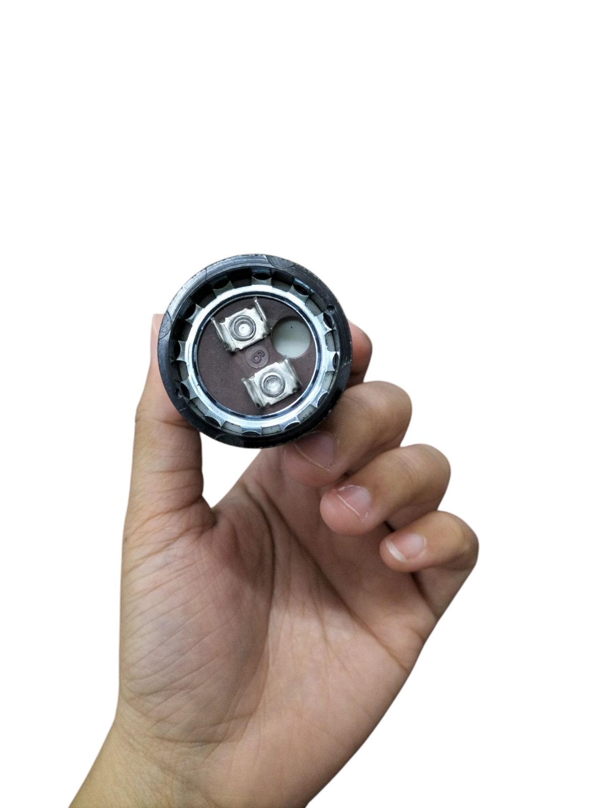 Mallory Motor Capacitor held in hand showcasing its compact design and electrical connections