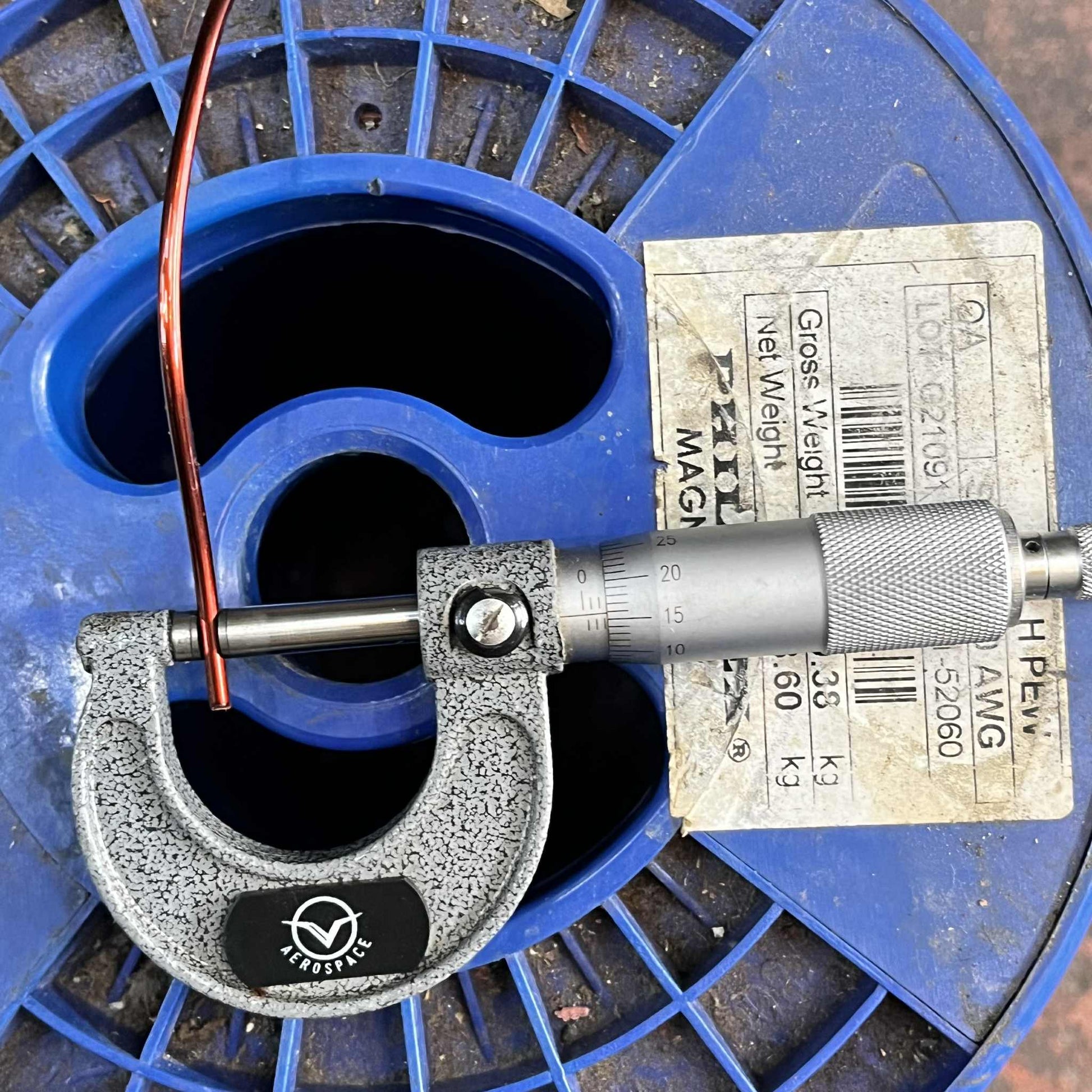 Philflex magnet wire AWG 10 being measured with a micrometer on a blue spool