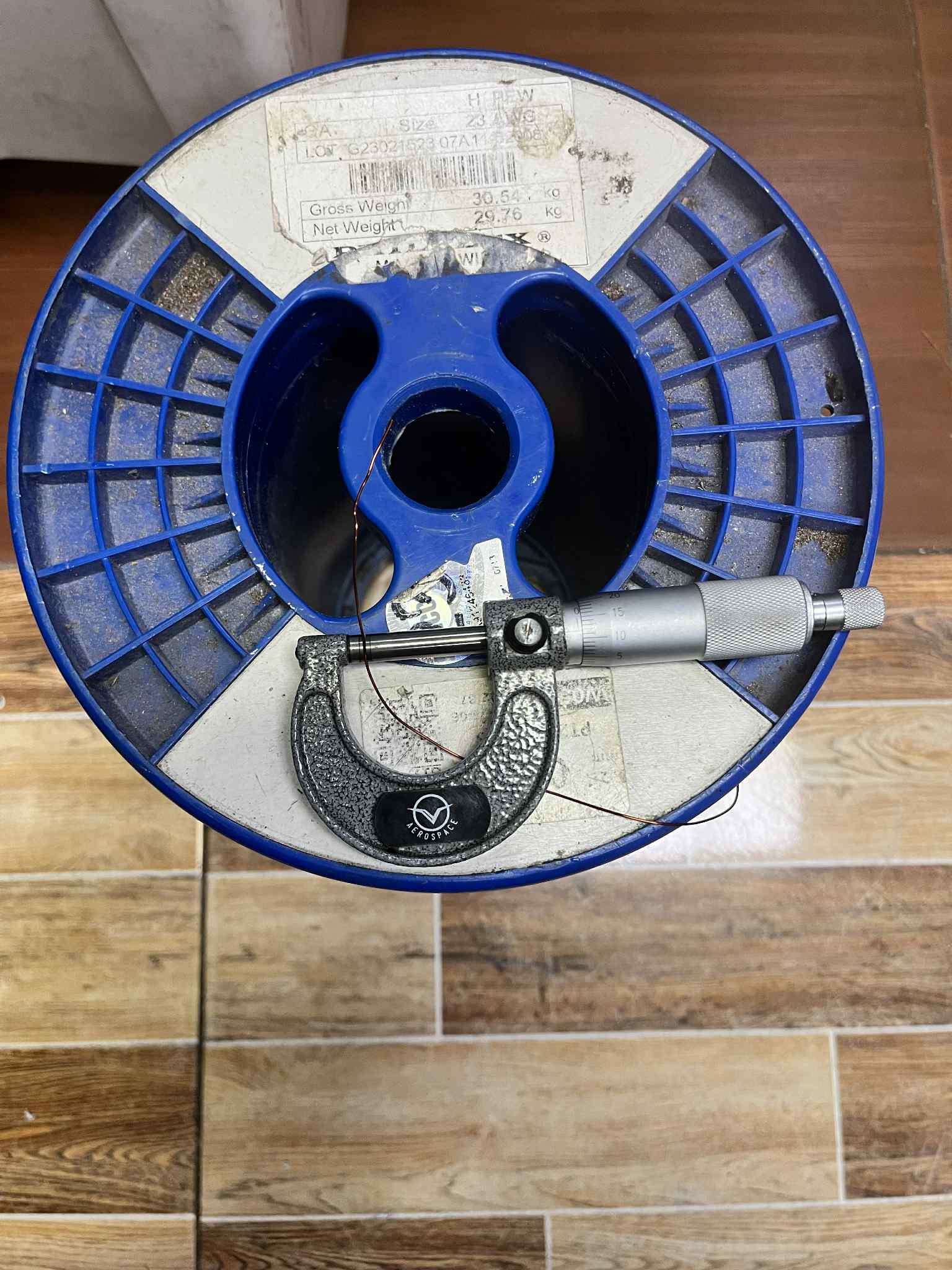 Philflex magnet wire AWG 23 on a blue spool with a measuring tool for precise measurements