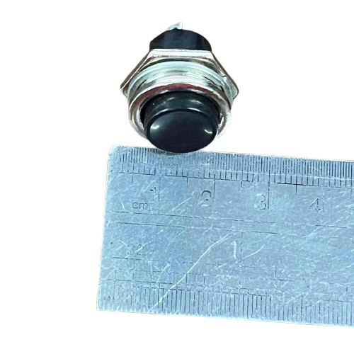 Push Button 1A 220V Black with a compact design near a ruler for size reference