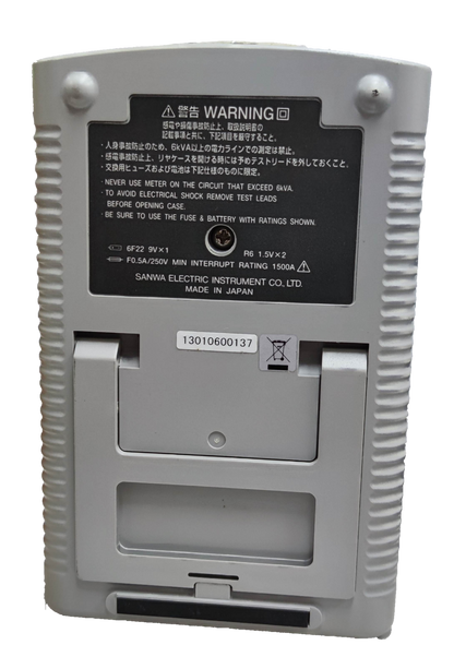 Back view of Sanwa Analog Multi-Tester Capacitance Tester showing battery compartment and warning label