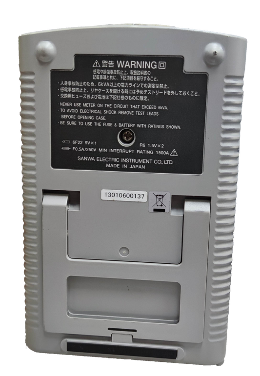 Back view of Sanwa Analog Multi-Tester Capacitance Tester showing battery compartment and warning label