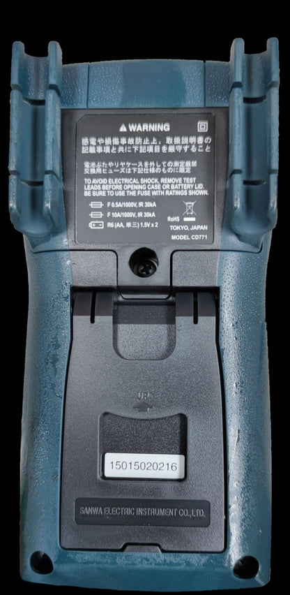 Back view of Sanwa CD771 Digital Multimeter showing battery compartment and warning labels