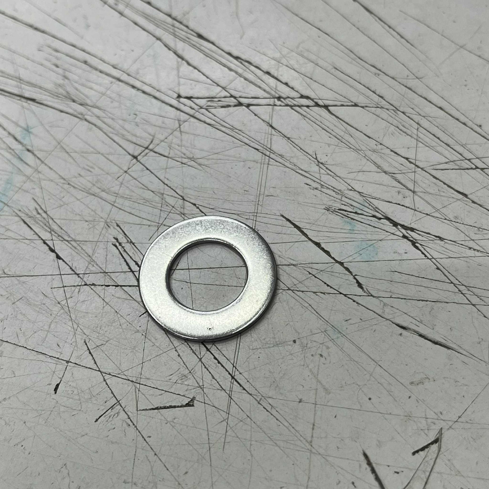 2cm Stainless Washer on a scratched metal surface for various fastening applications