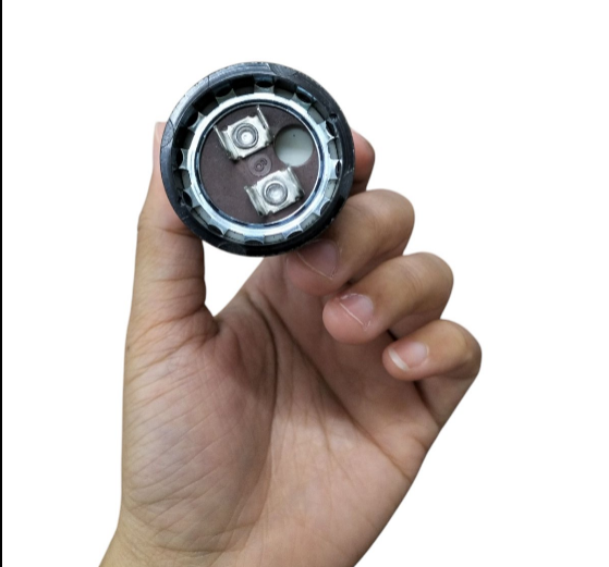 Hand holding a Mallory Starting Capacitor 36-43MFD 125V showcasing its connection terminals