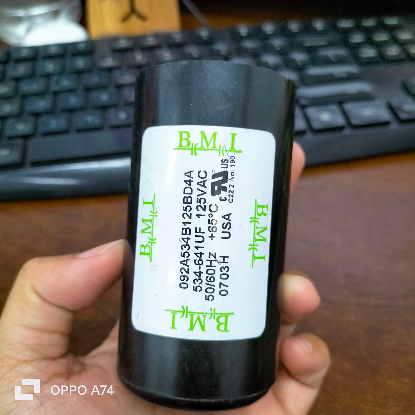 BMI Starting Capacitor 534-641 UF 125V held in hand with black casing and label details