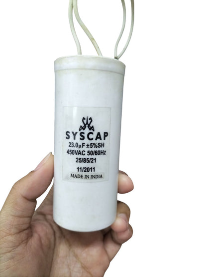 Syscap 23MFD 450VAC motor capacitor white cylindrical electrical component held in hand