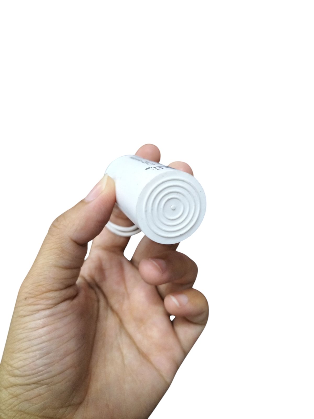 Syscap 250V AC motor start capacitor held in hand, designed for efficient motor performance