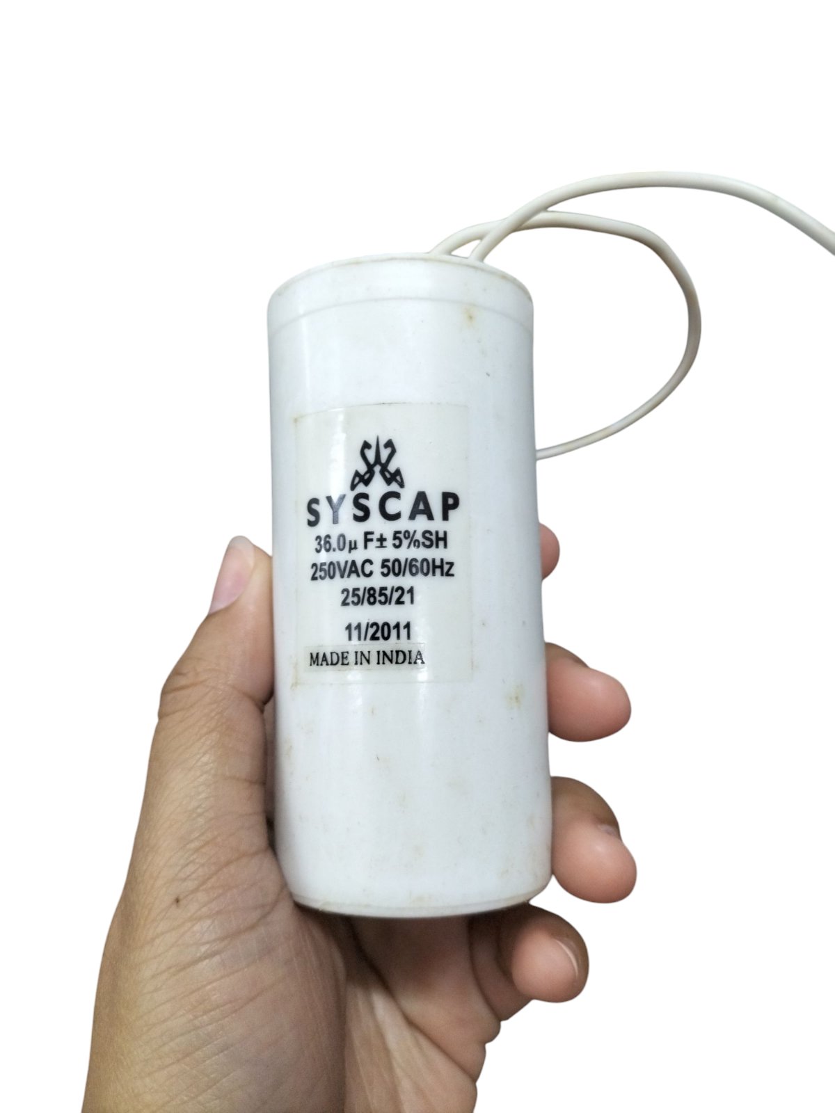 Syscap 36MFD motor capacitor 250VAC held in hand for electrical circuitry use