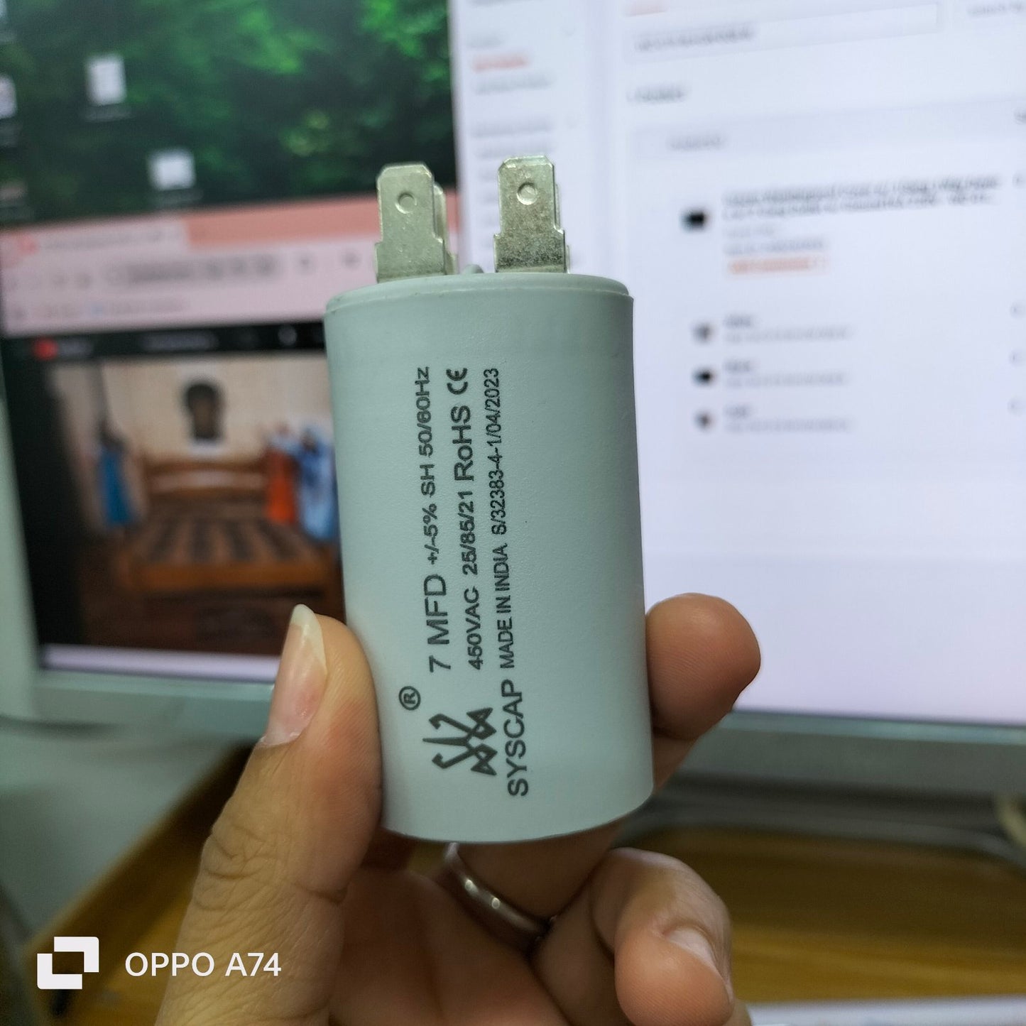 Syscap 7MFD 450Vac Run Capacitor held in hand for electrical circuitry and parts use