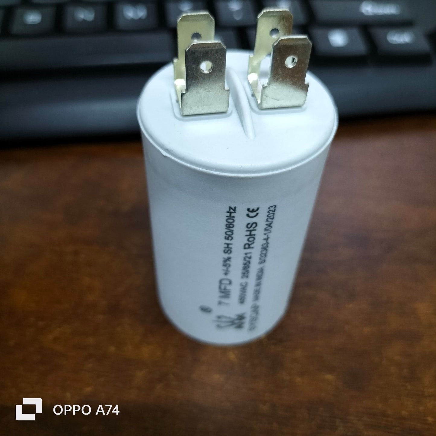 Syscap 7MFD 450Vac Run Capacitor electrical component with metal terminals on wooden surface