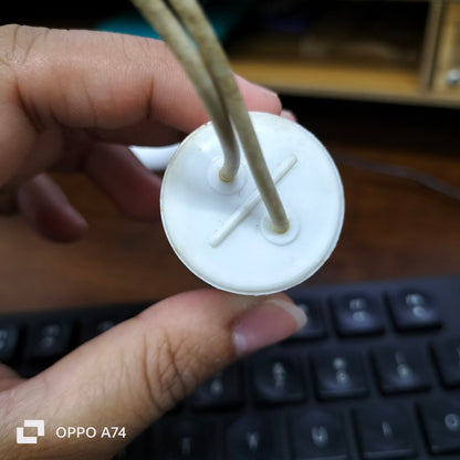 Hand holding a white apacitor 350V AC Electrical Part with two connecting wires