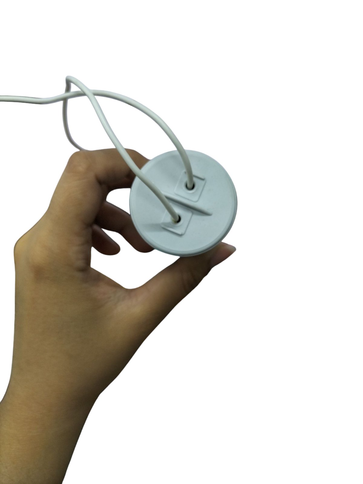 Hand holding Syscap motor running capacitor 22MFD with two white wires attached