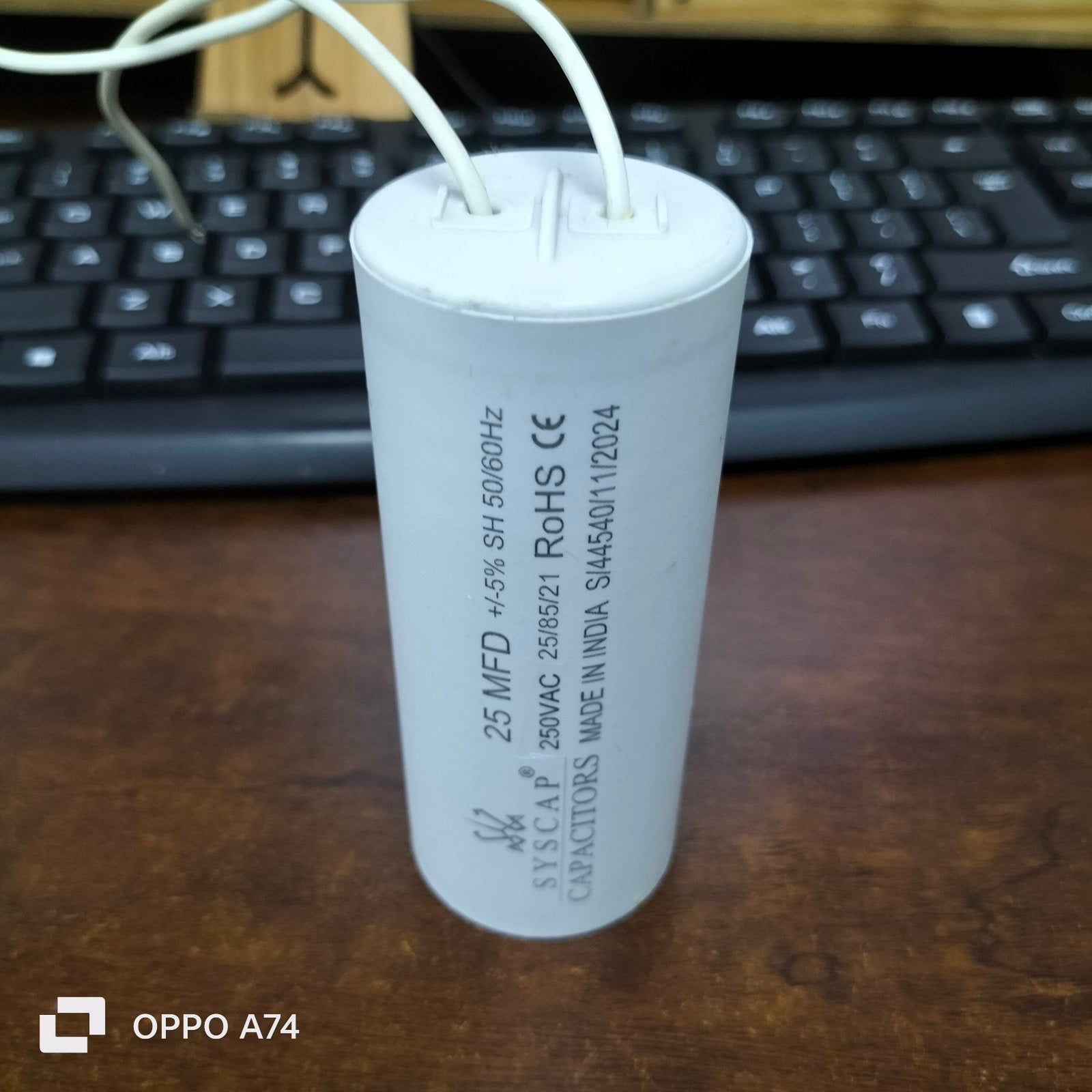 Syscap Running Capacitor 25MFD 250V with white cylindrical design and multiple wire connections