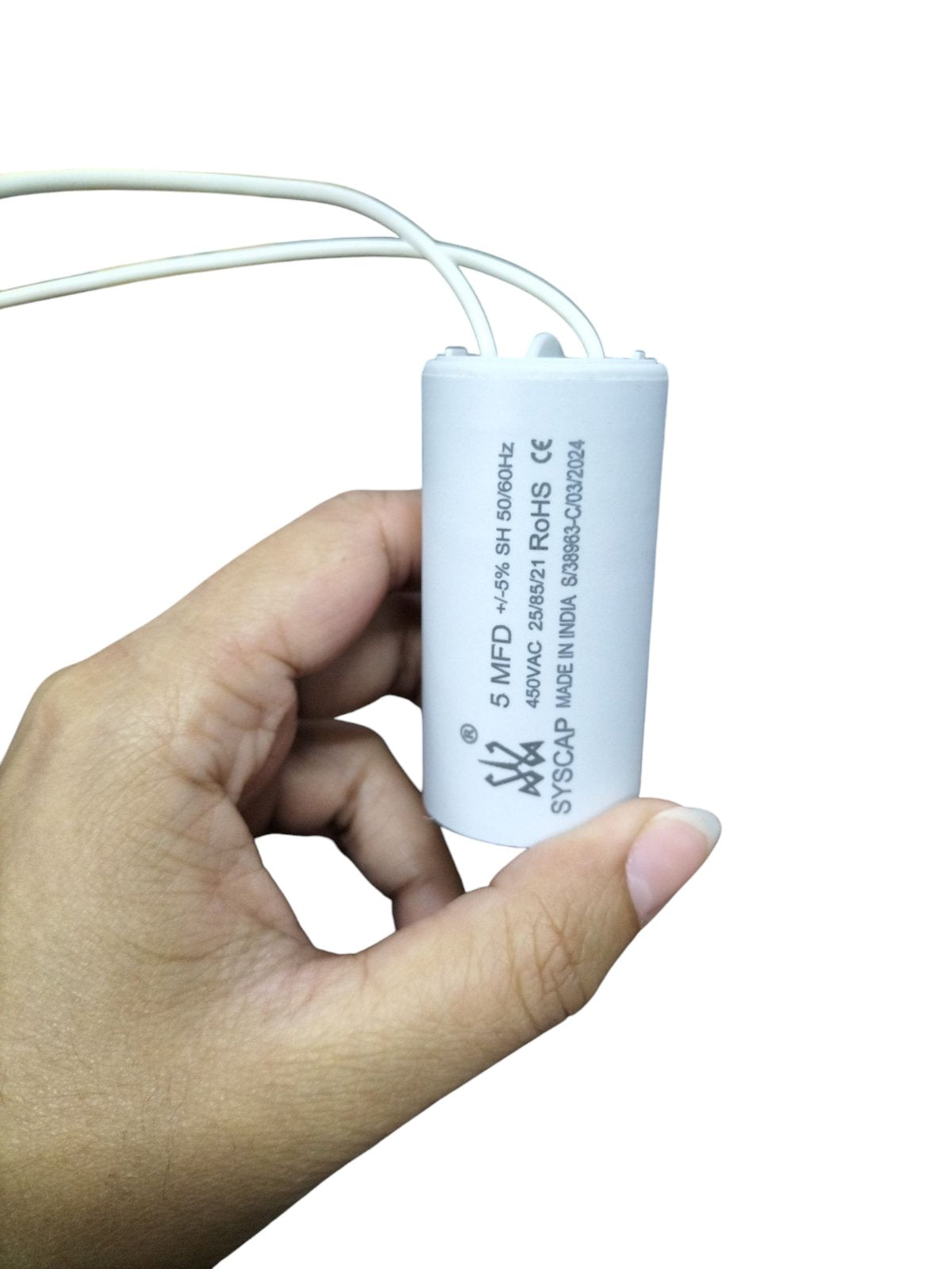 Syscap Running Capacitor 5MFD 450V held in hand, ideal for electrical circuitry applications